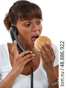 Office worker eating hamburger. Стоковое фото, агентство Ingram Publishing / Фотобанк Лори
