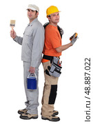 Tradesmen standing back to back. Стоковое фото, агентство Ingram Publishing / Фотобанк Лори