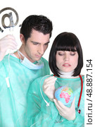 surgeons healing a little globe. Стоковое фото, агентство Ingram Publishing / Фотобанк Лори