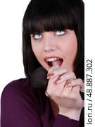 brunette looking upwards with makeup brush in hand. Стоковое фото, агентство Ingram Publishing / Фотобанк Лори