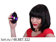 brunette woman showing a compact disc. Стоковое фото, агентство Ingram Publishing / Фотобанк Лори