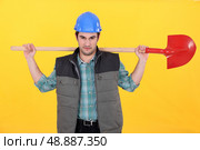 Scowling labourer carrying a shovel. Стоковое фото, агентство Ingram Publishing / Фотобанк Лори