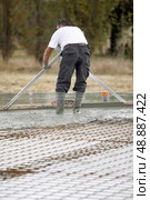 Man spreading concrete foundations. Стоковое фото, агентство Ingram Publishing / Фотобанк Лори