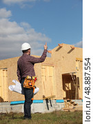 Foreman overseeing the wooden house build. Стоковое фото, агентство Ingram Publishing / Фотобанк Лори