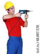 Builder wielding a power drill. Стоковое фото, агентство Ingram Publishing / Фотобанк Лори