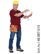 Tradesman holding a multimeter. Стоковое фото, агентство Ingram Publishing / Фотобанк Лори