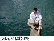 Man on a pontoon using computer. Стоковое фото, агентство Ingram Publishing / Фотобанк Лори