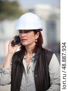 middleaged female architect making a call in construction site. Стоковое фото, агентство Ingram Publishing / Фотобанк Лори