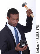 Man breaking a piggy bank. Стоковое фото, агентство Ingram Publishing / Фотобанк Лори