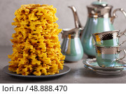 Traditional lithuanian cake, sakotis, is served on a gray table with a tea set. Стоковое фото, фотограф Елена Дмитриева / Фотобанк Лори