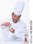 Chef putting salt on his meal. Стоковое фото, агентство Ingram Publishing / Фотобанк Лори