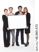 Four young executives holding a framed board left blank for your image. Стоковое фото, агентство Ingram Publishing / Фотобанк Лори