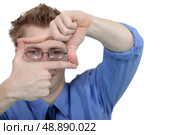 Young man using his fingers to frame his glasses. Стоковое фото, агентство Ingram Publishing / Фотобанк Лори