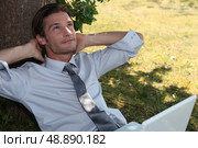 Young exec using a laptop under a tree. Стоковое фото, агентство Ingram Publishing / Фотобанк Лори