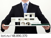 Architect holding scale replica of building. Стоковое фото, агентство Ingram Publishing / Фотобанк Лори