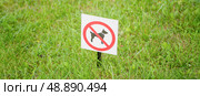 Bright sign dogs forbidden on a green lawn (2019 год). Редакционное фото, фотограф Дмитрий Попов / Фотобанк Лори