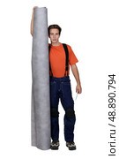 Tradesman holding a roll of linoleum flooring. Стоковое фото, агентство Ingram Publishing / Фотобанк Лори