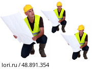 Multiple shot on foreman with plans kneeling. Стоковое фото, агентство Ingram Publishing / Фотобанк Лори