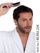 Man brushing his hair. Стоковое фото, агентство Ingram Publishing / Фотобанк Лори