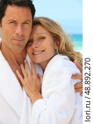 Couple in toweling robes by the ocean. Стоковое фото, агентство Ingram Publishing / Фотобанк Лори