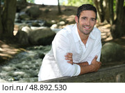 Man standing by a woodland stream. Стоковое фото, агентство Ingram Publishing / Фотобанк Лори