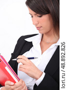 Smart woman ticking something off a file. Стоковое фото, агентство Ingram Publishing / Фотобанк Лори