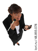 Businesswoman putting on makeup. Стоковое фото, агентство Ingram Publishing / Фотобанк Лори