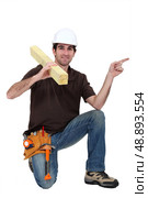 portrait of carpenter isolated pointing sidewards isolated on white. Стоковое фото, агентство Ingram Publishing / Фотобанк Лори