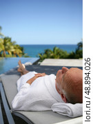 Elderly man relaxing poolside. Стоковое фото, агентство Ingram Publishing / Фотобанк Лори