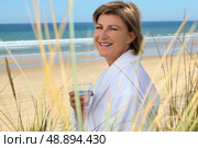 Woman with glass of water at the beach. Стоковое фото, агентство Ingram Publishing / Фотобанк Лори