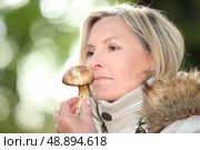 Woman sniffing a mushroom. Стоковое фото, агентство Ingram Publishing / Фотобанк Лори