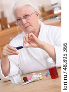 Old lady taking medication. Стоковое фото, агентство Ingram Publishing / Фотобанк Лори