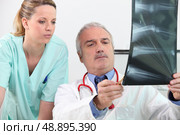 Doctor and his assistant. Стоковое фото, агентство Ingram Publishing / Фотобанк Лори