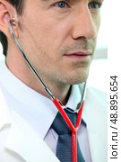 Doctor listening to a patient’s heartbeat. Стоковое фото, агентство Ingram Publishing / Фотобанк Лори