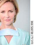 Female medic in scrubs with facemask. Стоковое фото, агентство Ingram Publishing / Фотобанк Лори