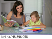 Mother helping daughter with schoolwork. Стоковое фото, агентство Ingram Publishing / Фотобанк Лори