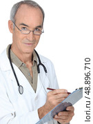 Medical professional writing on a clipboard. Стоковое фото, агентство Ingram Publishing / Фотобанк Лори
