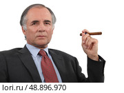 A mature businessman smoking a cigar. Стоковое фото, агентство Ingram Publishing / Фотобанк Лори