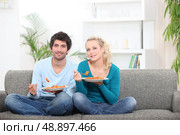 Couple having dinner on their couch. Стоковое фото, агентство Ingram Publishing / Фотобанк Лори