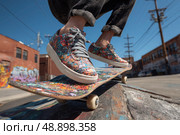 A man is skateboarding on a skateboard with colorful designs on it. Стоковое AI-изображение, AI-художник Ярославский Максим / Фотобанк Лори