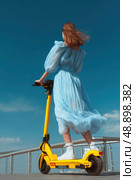 A woman is riding a yellow scooter. Стоковое AI-изображение, AI-художник Ярославский Максим / Фотобанк Лори