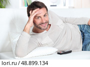 Young man on couch. Стоковое фото, агентство Ingram Publishing / Фотобанк Лори
