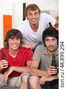 three 18 years old boys drinking beer at home. Стоковое фото, агентство Ingram Publishing / Фотобанк Лори