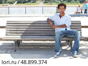 Young man sitting on a public bench. Стоковое фото, агентство Ingram Publishing / Фотобанк Лори