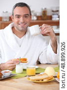 Man having breakfast in dressing gown. Стоковое фото, агентство Ingram Publishing / Фотобанк Лори