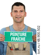 Painter holding a fresh paint sign. Стоковое фото, агентство Ingram Publishing / Фотобанк Лори