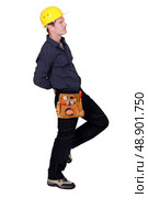 Tradesman hiding something behind his back. Стоковое фото, агентство Ingram Publishing / Фотобанк Лори
