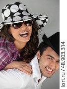 Couple messing around in hats. Стоковое фото, агентство Ingram Publishing / Фотобанк Лори
