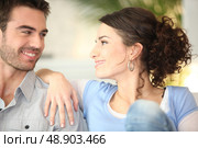 Affectionate young couple on couch. Стоковое фото, агентство Ingram Publishing / Фотобанк Лори