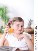 Blond girl drinking orange juice in the kitchen. Стоковое фото, агентство Ingram Publishing / Фотобанк Лори